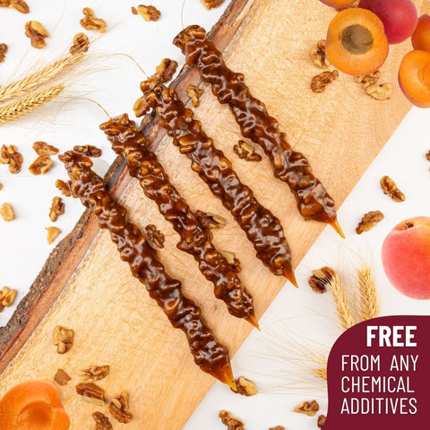 Delicious Apricot Walnut Chella Churchkhela on a board with ingredients, free from chemical additives.