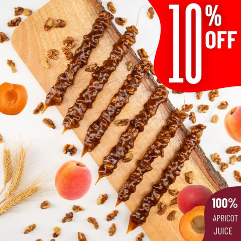 Apricot Walnut Chella Churchkhela sticks on board with 10% off, featuring 100% apricot juice and walnuts, healthy natural snack.