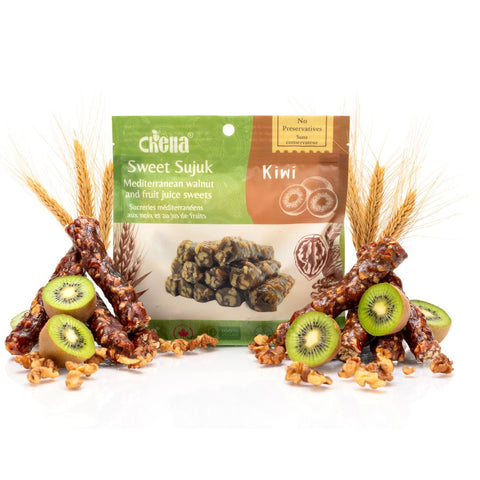 Package of Chella FruityNuts Bar kiwi and walnut flavour surrounded by clusters of shiny bars and wheat stalks on a white background.