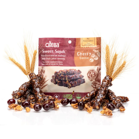 Package of Chella FruityNuts Bar cherry and walnut flavour surrounded by clusters of shiny bars and wheat stalks on a white background.