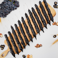 Grape Hazelnut Chella Churchkhela on wooden board with grapes and hazelnuts, showcasing natural ingredients of this healthy treat.