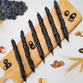 Grape Hazelnut Chella Churchkhela on wooden board with grapes and hazelnuts, showcasing natural ingredients in a healthy sweet treat.