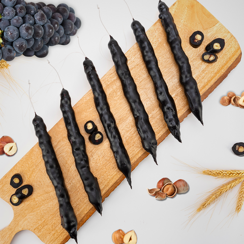 Grape Hazelnut Chella Churchkhela on wooden board with grapes and hazelnuts, showcasing natural ingredients in a healthy sweet treat.