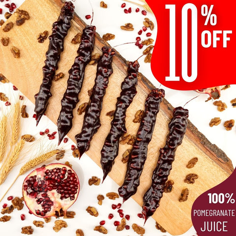 Pomegranate Walnut Chella Churchkhela on wooden board with 10% off, featuring 100% pomegranate juice ingredients.